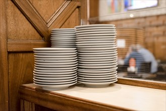 Piles of white dishes in a restaurant