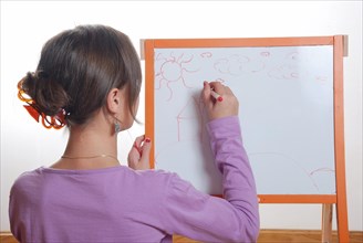 Young girl drawing on the white board