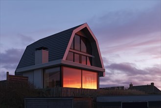 Modern holiday home, sunset reflected in the window, Dutch North Sea coast, Bergen aan Zee, province North Holland, Netherlands
