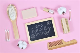 Concept for Eco friendly living with wooden beauty and hygiene products like comb and soap on pink background