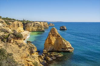 Beautiful cliffs and rock formations by the Atlantic Ocean at Marinha Beach in Algarve, Portugal, Europe