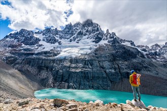 Hiker standing at the lagoon, glacial lake at Cerro Castillo mountain, Cerro Castillo National Park, Aysen, Patagonia, Chile, South America