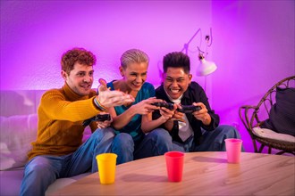 Group of young friends play video games together on the sofa at home, purple led