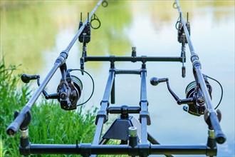 Close-up of a rod holder with alarms and two rods with their reels in fishing action