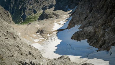 View of the glacier in the alps and tourists marching on it. Zugspitze massif in the bavarian alps, Dolomites, Italy, Europe