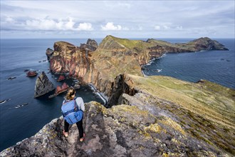 Hiker, coastal landscape, cliffs and sea, Miradouro da Ponta do Rosto, rugged coastline with rock formations, Cape Ponta de Sao Lourenco, Madeira, Portugal, Europe