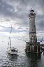 Sailing boat leaving Lindau harbour, New Lindau Lighthouse, Lindau Island, Lake Constance, Bavaria, Germany, Europe