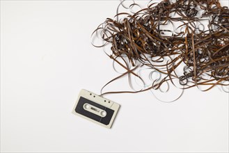 Old compact cassette with tape spaghetti, white background