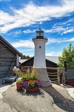 Small lighthouse decorated with flowers, Kaeringsund fishing village, Fasta Aland, Aland Islands, Aland Islands, Finland, Europe