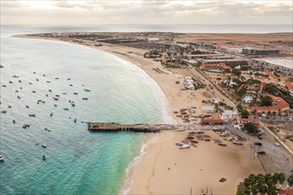 Pier and boats on turquoise water in city of Santa Maria, island of Sal, Cape Verde, Africa