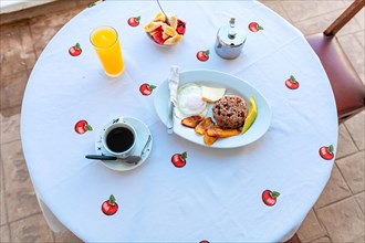 Top view of a breakfast served on the table. A traditional breakfast served on the table, gallopinto with coffee and fruit salad and orange juice