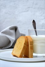 Rusk and glass of milk with spoon
