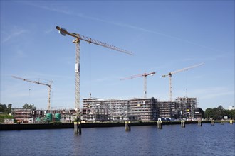 Modern residential building on the Hunte, construction site, construction cranes, new building, Oldenburg in Oldenburg, Lower Saxony, Germany, Europe