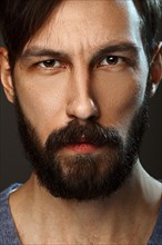 Closeup portrait of serious man with beard and mustache looking straight severe severe