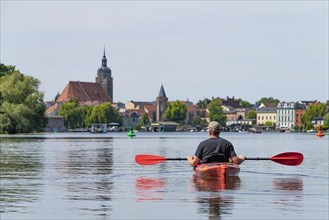 Paddlers in a kayak on the Havel, with St. Catherines Church in the background, Brandenburg an der Havel, Brandenburg, Germany, Europe