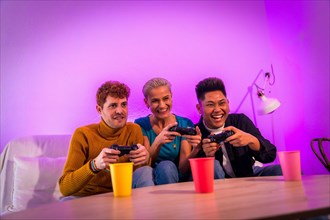 Group of young friends playing video games together on the sofa at home, purple led, racing game