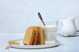 Rusk and glass of milk with spoon