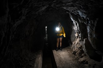 Hiker in a tunnel at Levada do Moinho, Ponta do Sol, Madeira, Portugal, Europe