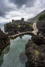 Natural volcanic rock pools, rocky coastline, Piscinas Naturais Velhas, Aquarium Aquario da Madeira in the back, Porto Moniz, Madeira, Portugal, Europe