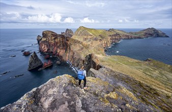Hiker, coastal landscape, cliffs and sea, Miradouro da Ponta do Rosto, rugged coastline with rock formations, Cape Ponta de Sao Lourenco, Madeira, Portugal, Europe