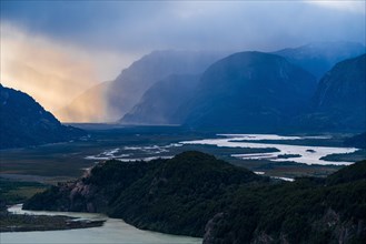 Rays of sunshine break through the rain clouds over the river valley of the Rio Ibanez, Cerro Castillo National Park, Aysen, Patagonia, Chile, South America