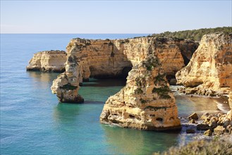 Beautiful cliffs and rock formations by the Atlantic Ocean at Marinha Beach in Algarve, Portugal, Europe