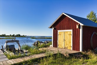 Red boathouse, idyll on the Baltic coast, Bjoerkoeby, Korsholm, Mustasaari, Kvarken Archipelago Nature Reserve, UNESCO World Heritage Site, Ostrobothnia, Finland, Europe