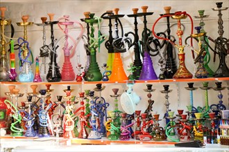 Group of eastern hookahs placed of various colors on a shelf