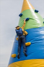 A boy climbing on cone shaped climbing course