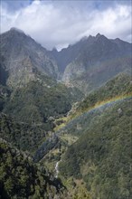 Rainbow in the mountains, Miradouro dos Balcoes, Ribeira da Metade mountain valley and the central mountain range, Madeira, Portugal, Europe