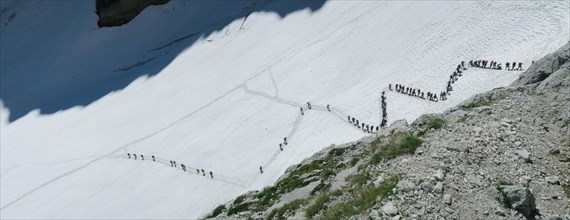 View from above on people walking on the zigzag glacier. Big queue, congestion. Zugspitze massif in the bavarian alps, Dolomites, Italy, Europe