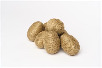 Hand wrapped easter eggs with jute twine, isolated white background. Studio