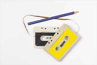 Old compact cassettes with pencil on white background, copying room