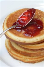 Pancake with raspberry jam and spoon