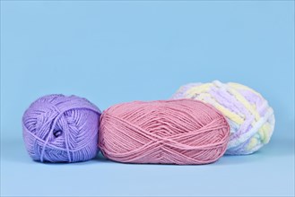 Balls of wool on pastel blue background