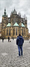 People looking at Saint Vitus Cathedral standing within Prague Castle. It is the Czech Republics most important cathedral, and one of the most magnificent in Europe