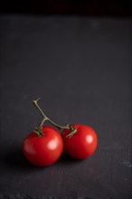 Red tomatoes in bowl on slate, fitness, cooking, vegetarian, vegan, vitamins, cultivation, healthy, close up, several, portrait format