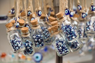 Little transparent glass bottle filled with blue evil eye beads