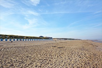 View on beach district called Paal 20 with beach huts in distance on island Texel in the netherlands on summer day with blue sky