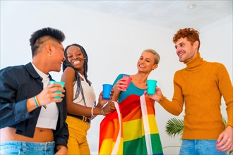 LGBT pride, lgbt rainbow flag, group of friends dancing and toasting with glasses in a house at party