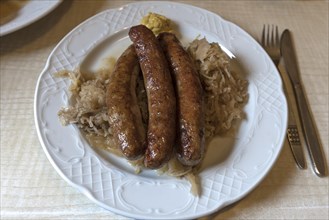 Three bratwursts on sauerkraut in a Franconian inn, Bavaria, Germany, Europe