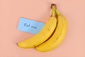 Two banana fruits with note saying eat me