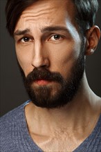 Closeup portrait of surprised man with beard and mustache looking worried