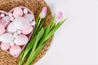 Easter eggs in heart shaped plate and tulip flowers with copy space