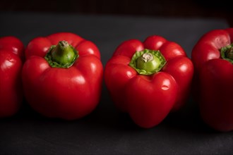 Red peppers in row on slate, fitness, cooking, vegetarian, vegan, vitamins, growing, garden, healthy, close up, kitchen