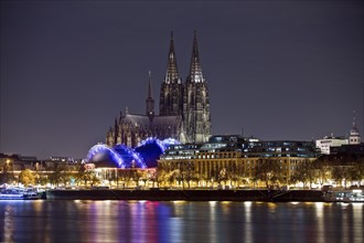 City panorama with only dimly lit Cologne Cathedral and the Rhine at night, Cologne, Rhineland, North Rhine-Westphalia, Germany, Europe