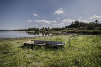 A boat lies at low water level at a dried up river bank, Waldhufen, Germany, Due to persistent heat and lack of precipitation many water bodies in Saxony are dried up or carry little water, Waldhufen,...