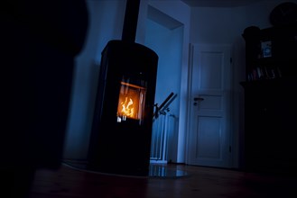 Symbolic photo: A fire burns in a stove in a flat. Berlin, 03.03.2023, Berlin, Germany, Europe