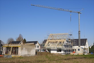 Residential house with scaffolding and open roof truss, construction site in a new housing estate, Kamen, North Rhine-Westphalia, Germany, Europe