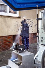 Removal of graffiti from house wall, high-pressure cleaner, residential area, Duesseldorf, North Rhine-Westphalia, Germany, Europe